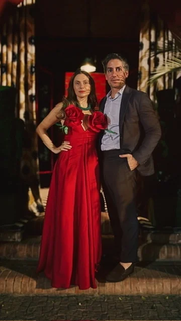 Sahra-Josephine in a red gown with a companion at night