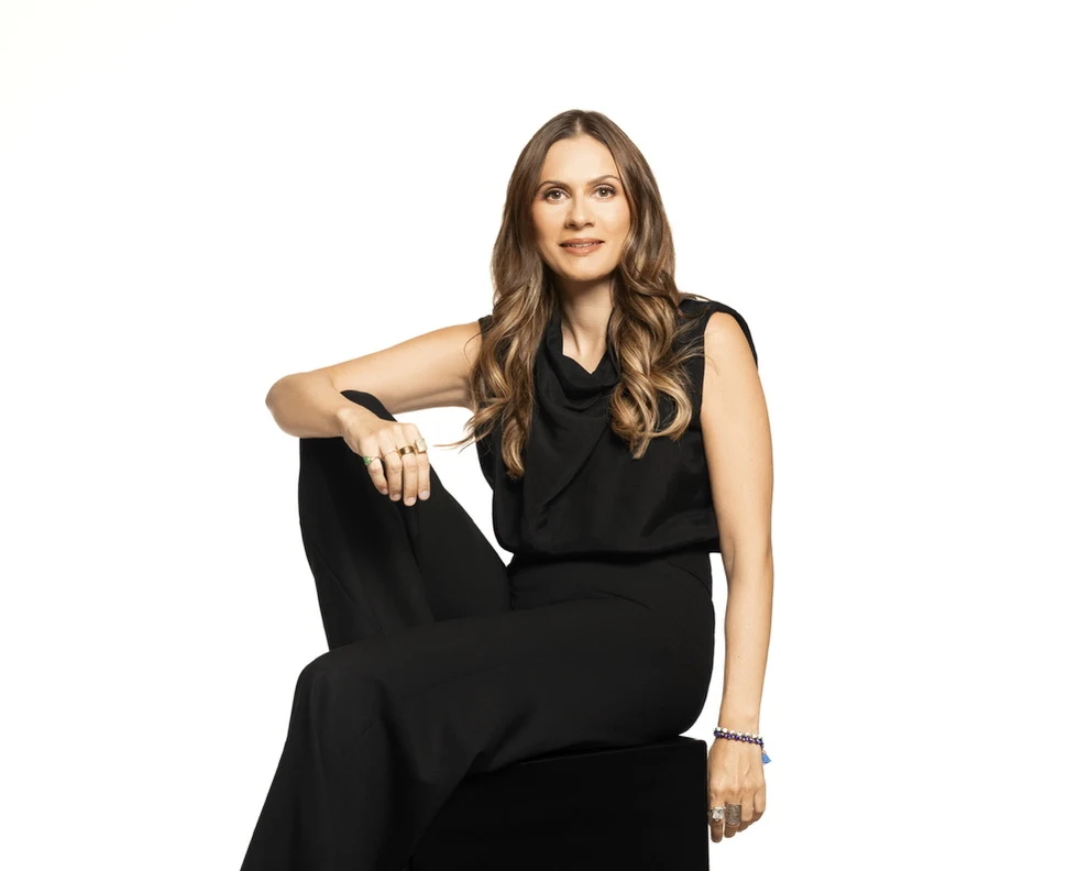 Sahra-Josephine seated in black against a white background
