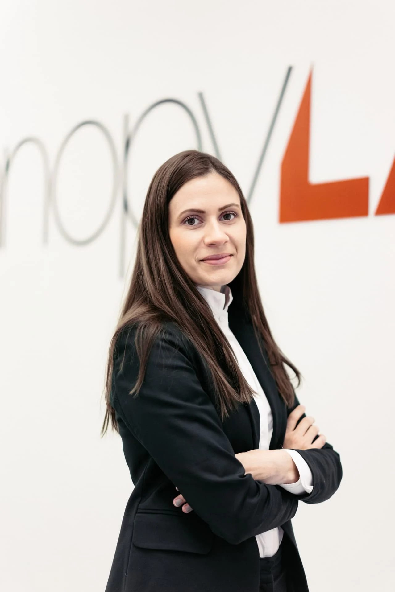 Sahra-Josephine con los brazos cruzados frente al logotipo de CanopyLAB