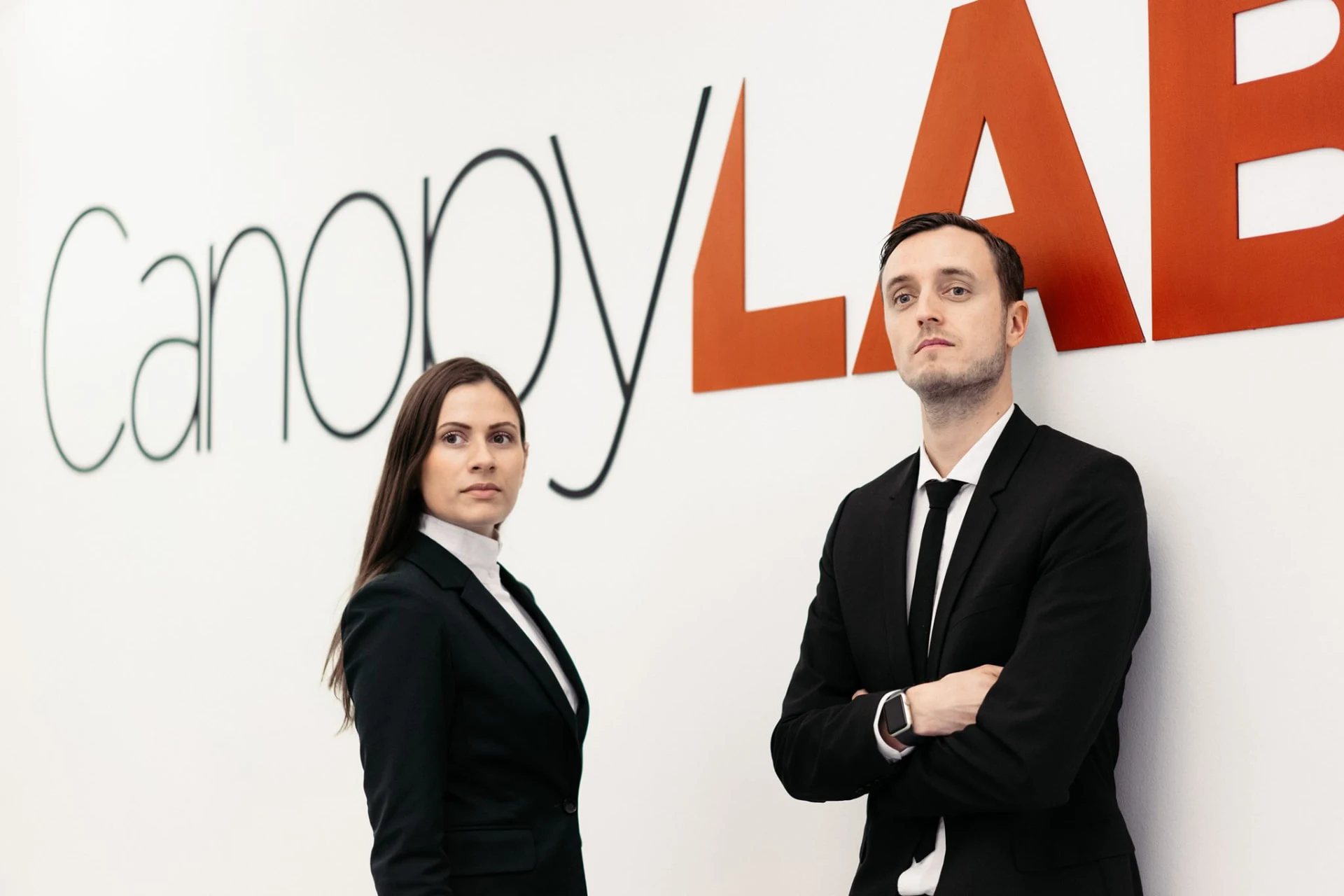 Sahra-Josephine and a colleague in front of the CanopyLAB logo