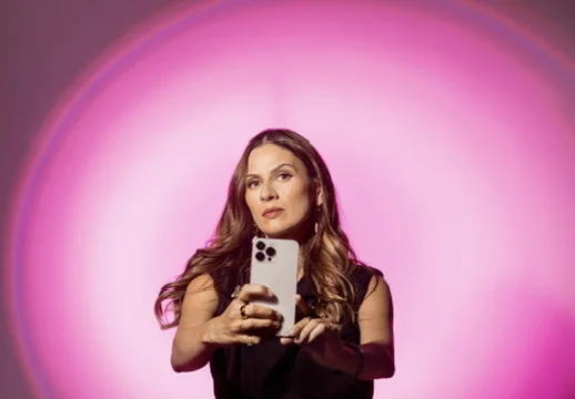 Sahra-Josephine holding up a phone against a pink light